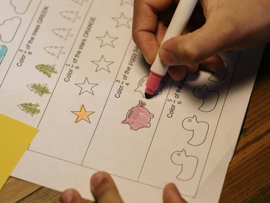 Child coloring shapes as part of a homeschool educational activity indoors with a marker.